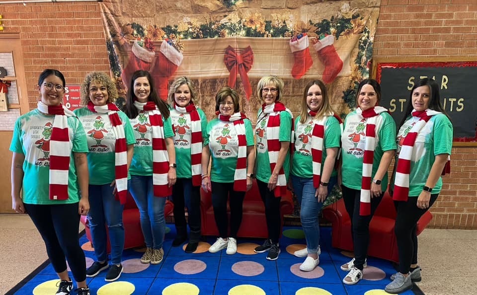 East Ridge Staff got into the Holiday Spirit with a Team Dress Up Day!  teachers in festive shirts in front of the fake fireplace 