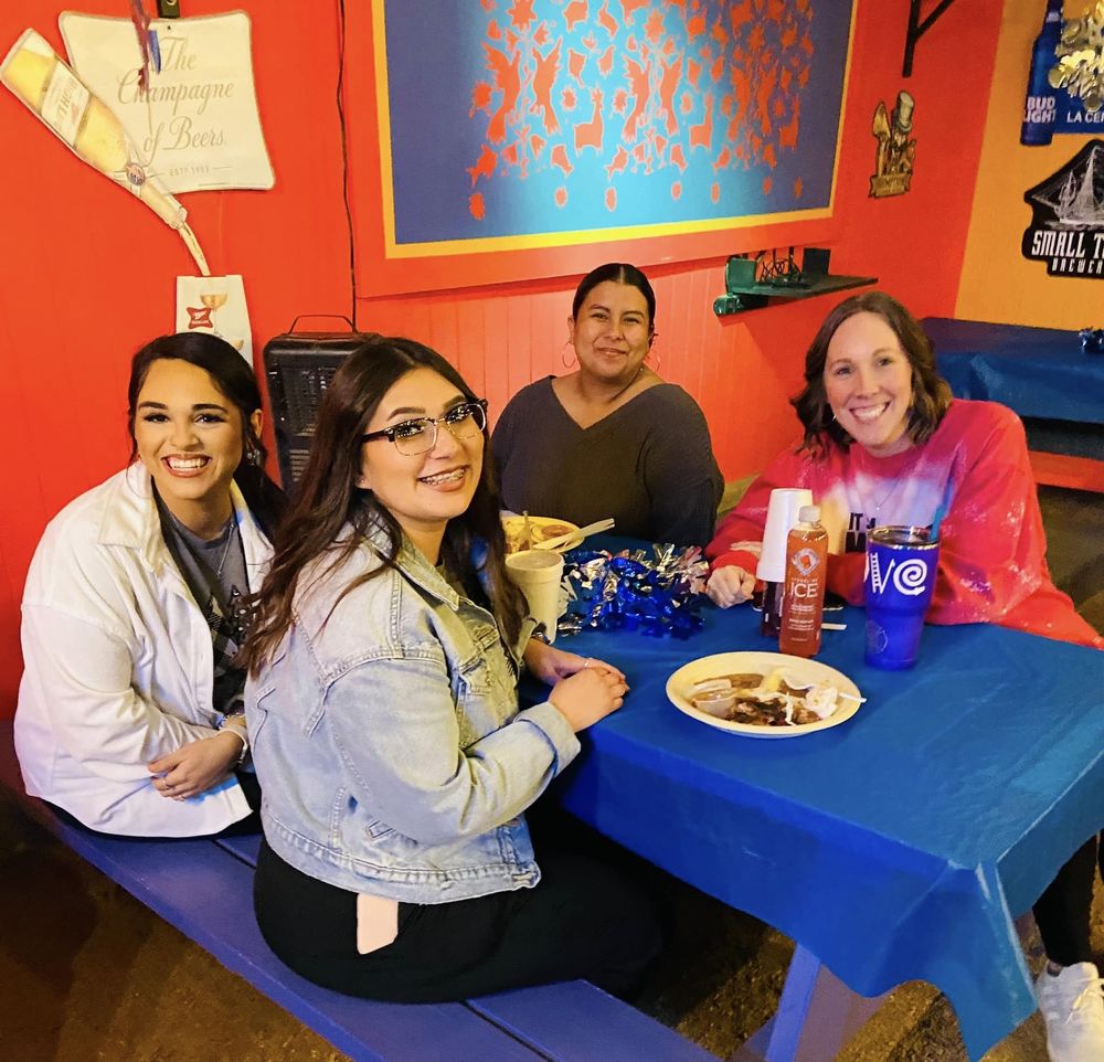 teachers sitting at a blue table eating food
